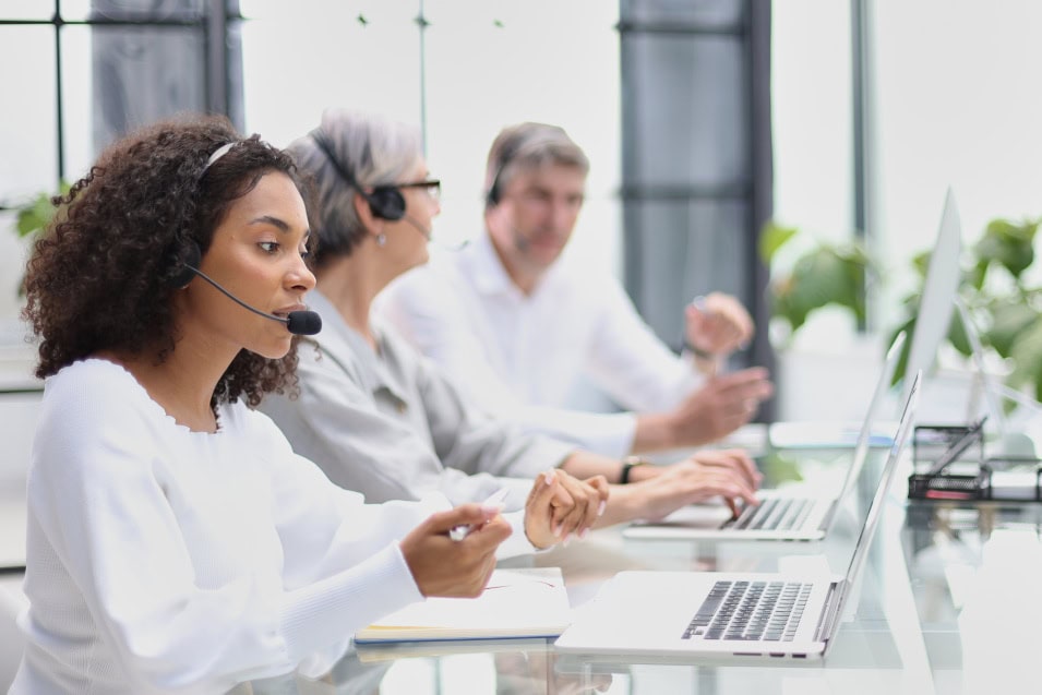 Drei Personen arbeiten mit Headsets bei einem Personaldienstleister in Stuttgart
