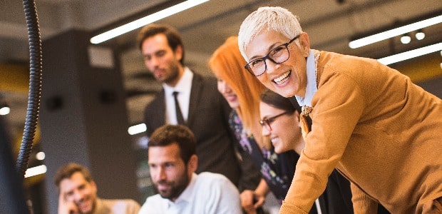 Senior businesswoman working together with young business people in office