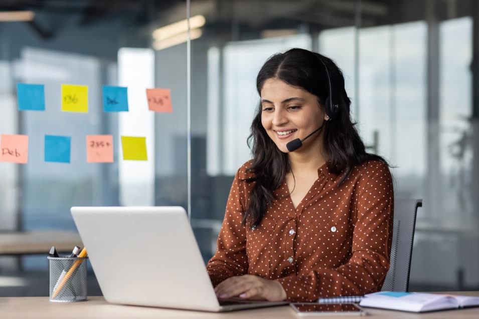 Eine lächelnde Frau mit Headset arbeitet bei der Personalvermittlungsfirma Dr. Stern Stuttgart GmbH