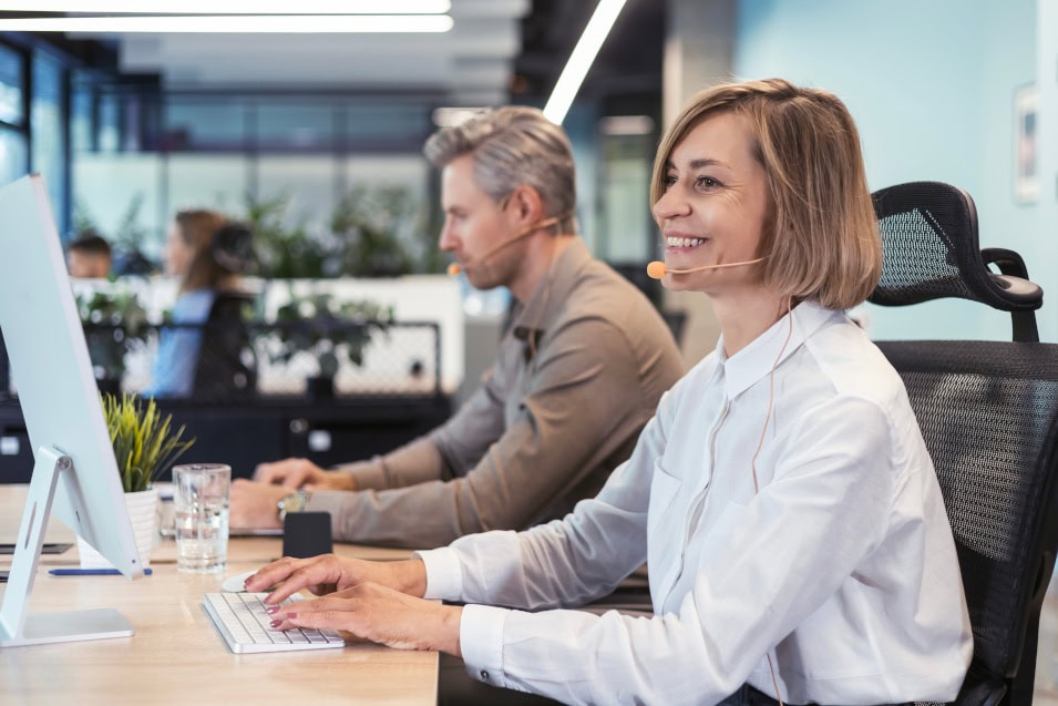 Eine lächelnde Frau mit Headset arbeitet bei Personalvermittlungsfirma Dr. Stern Stuttgart GmbH