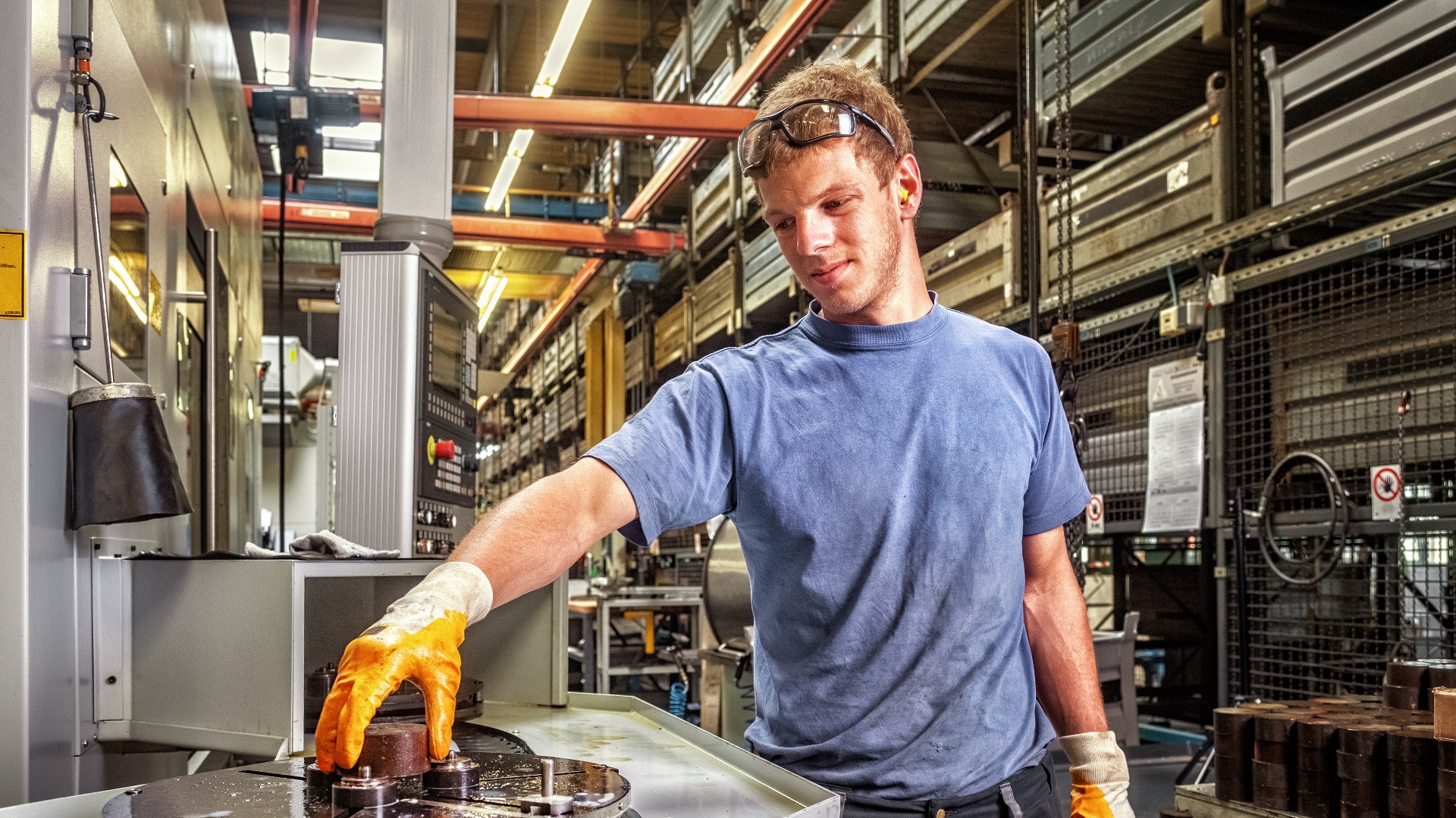 Facharbeiter, der eine digital programmierte Werkzeugmaschine steuert